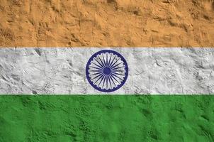 India flag depicted in bright paint colors on old relief plastering wall. Textured banner on rough background photo