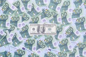 100 dollars bill is lies on a set of green monetary denominations of 100 euros. A lot of money forms an infinite heap photo