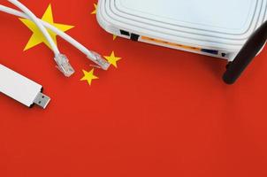 China flag depicted on table with internet rj45 cable, wireless usb wifi adapter and router. Internet connection concept photo