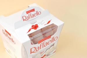 KHARKIV, UKRAINE - MAY 02, 2021 Raffaello candies on beige background. Raffaello is a spherical coconut almond confection that Italian manufacturer Ferrero brought to the market in 1990 photo