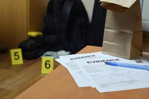 la cadena de evidencia de las etiquetas de custodia y la bolsa de papel marrón se encuentran con grandes paquetes de heroína y paquetes de billetes de dinero como evidencia en el proceso de investigación de la escena del crimen en el fondo foto