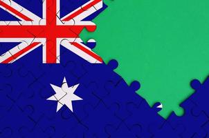 Australia flag  is depicted on a completed jigsaw puzzle with free green copy space on the right side photo