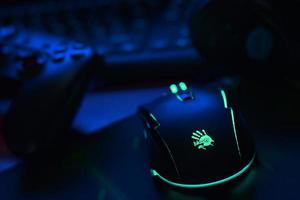 KHARKIV, UKRAINE - MAY 2, 2021 Gamesir g3s video game controller and Bloody p93 gaming mouse on office table with a4tech keyboard and headphones photo