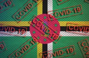Dominica flag and many red Covid-19 stamps. Coronavirus or 2019-nCov virus concept photo