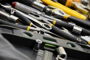 Handyman tool kit on black wooden table. Many wrenches and screwdrivers, pilers and other tools for any types of repair or construction works. Repairman tools photo