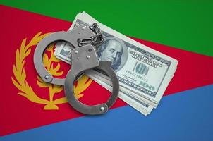 Eritrea flag  with handcuffs and a bundle of dollars. Currency corruption in the country. Financial crimes photo