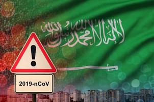 Saudi Arabia flag and Coronavirus 2019-nCoV alert sign. Concept of high probability of novel coronavirus outbreak through traveling tourists photo