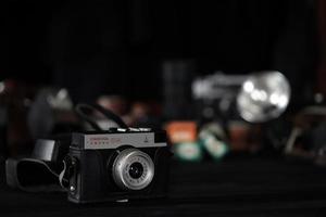 KHARKOV, UKRAINE - APRIL 27, 2021 Smena 8m Film photo camera and another old retro photo equipment on black wooden table in photographer darkroom. Photographic gear from soviet union