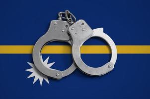 Nauru flag  and police handcuffs. The concept of observance of the law in the country and protection from crime photo