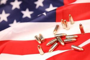 Many yellow 9mm bullets and cartridges on United States flag. Concept of gun trafficking on USA territory or special ops photo