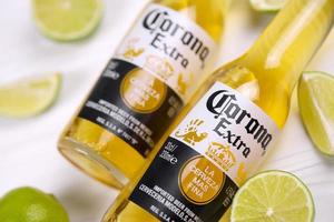 KHARKOV, UKRAINE - DECEMBER 9, 2020 Bottles of Corona Extra Beer with lime slices. Corona produced by Grupo Modelo with Anheuser Busch InBev most popular imported beer in the US photo