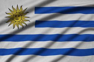 Uruguay flag  is depicted on a sports cloth fabric with many folds. Sport team banner photo