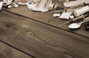 A lot of narcotic substances and devices for the preparation of drugs lie on an old wooden table photo