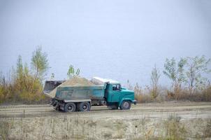 Dump truck transports sand and other minerals in the mining quarry. Heavy industry photo