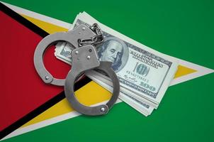 Guyana flag  with handcuffs and a bundle of dollars. Currency corruption in the country. Financial crimes photo