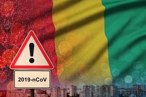 Guinea flag and Coronavirus 2019-nCoV alert sign. Concept of high probability of novel coronavirus outbreak through traveling tourists photo