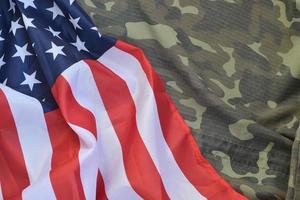 bandera de los estados unidos de américa y chaqueta de uniforme militar doblada. banner de fondo conceptual de símbolos militares para fiestas patrióticas americanas foto