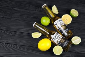 KHARKOV, UKRAINE - DECEMBER 9, 2020 Bottles of Corona Extra Beer with lime slices. Corona produced by Grupo Modelo with Anheuser Busch InBev most popular imported beer in the US photo