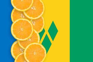 Saint Vincent and the Grenadines flag and citrus fruit slices vertical row photo