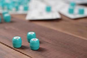 Many barrels with numbers and cards for lotto or russian bingo table game on wooden surface. Russian lotto has similar rules to classical worldwide bingo photo