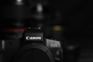 KHARKIV, UKRAINE - MAY 02, 2021 Canon EOS R photocamera with Canon lenses on black table. Canon EOS R is 30mp full-frame mirrorless interchangeable-lens camera launched by Canon in 2018 photo