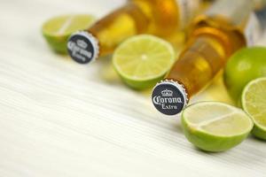 KHARKOV, UKRAINE - DECEMBER 9, 2020 Bottles of Corona Extra Beer with lime slices. Corona produced by Grupo Modelo with Anheuser Busch InBev most popular imported beer in the US photo