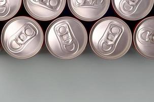 muchas latas de aluminio nuevas de refrescos o envases de bebidas energéticas. concepto de fabricación de bebidas y producción en masa foto