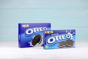 KHARKIV, UKRAINE - MAY 02, 2021 Oreo blue product box on white and light blue wooden background. Oreo is a sandwich cookie with a sweet cream is the best selling cookie in the US photo