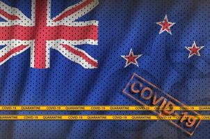 New Zealand flag and orange Covid-19 stamp with border tape. Coronavirus or 2019-nCov virus concept photo