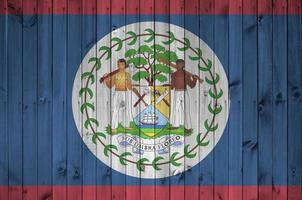 Belize flag depicted in bright paint colors on old wooden wall. Textured banner on rough background photo
