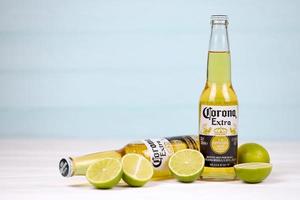 KHARKOV, UKRAINE - DECEMBER 9, 2020 Bottles of Corona Extra Beer with lime slices. Corona produced by Grupo Modelo with Anheuser Busch InBev most popular imported beer in the US photo