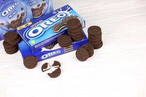 KHARKIV, UKRAINE - MAY 02, 2021 Oreo sandwich cookies and blue product boxes on white table. Oreo is a sandwich cookie with a sweet cream is the best selling cookie in the US photo