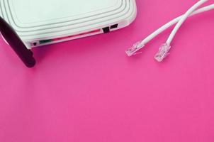 Internet router and Internet cable plugs lie on a bright pink background. Items required for Internet photo