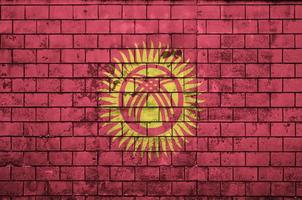 Kyrgyzstan flag is painted onto an old brick wall photo