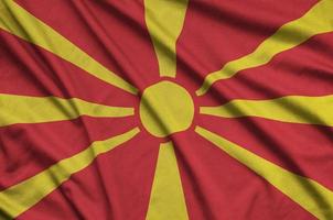 Macedonia flag  is depicted on a sports cloth fabric with many folds. Sport team banner photo