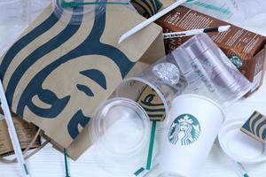 KHARKOV, UKRAINE - MARCH 15, 2021 Starbucks disposable used production on white table. Starbucks Corporation is multinational chain of coffeehouses headquartered in Seattle, Washington photo