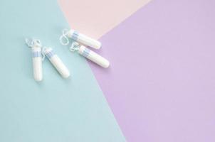 Flat lay composition with menstrual tampons on blue pink and lilac pastel background photo
