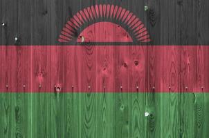 Malawi flag depicted in bright paint colors on old wooden wall. Textured banner on rough background photo