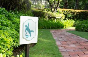 slippery sign beside walkway in garden in morning photo