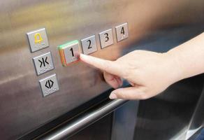 woman's hand pressing on elevator button photo