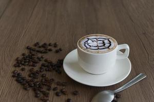 Coffee in a mug  and beans on a wood grain background photo