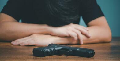 Sad and depressed Businessman with gun on the desk. photo