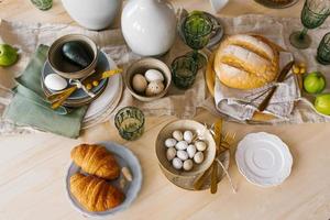 mesa festiva de pascua con huevos, pasteles y frutas. vista superior de la mesa de comedor decorada foto