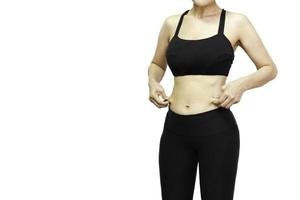 Skinny woman in sport wear hand holding skin on her belly in clipping path. photo