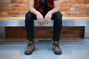 Young stylish guy sitting on the bench in a supermarket. Man waiting for his girlfriend. photo