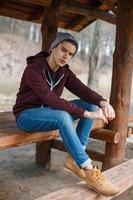 Young handsome man in a hat and leather boots in a forest photo