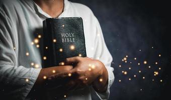 Worship christian with bible concept. Young woman person hand holding holy bible with study at home. Adult female christian reading book in church. Girl learning religion spirituality and pray to god. photo