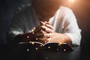 adorar a los cristianos con el concepto de la biblia. mujer joven persona mano sosteniendo la sagrada biblia con estudio en casa. libro de lectura cristiana femenina adulta en la iglesia. niña aprendiendo religión espiritualidad y orando a dios. foto