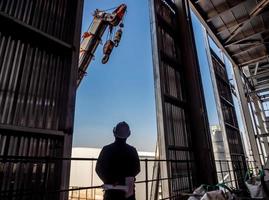 Hoist of crane at the window of industrial plant photo