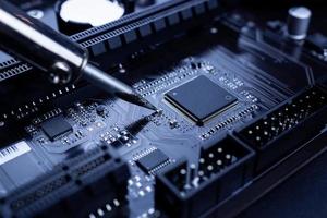 Repairman is soldering the motherboard of electronic device photo